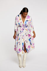 a woman wearing R/H Studio Shangri Dress in Rain Dance print with white boots. 
