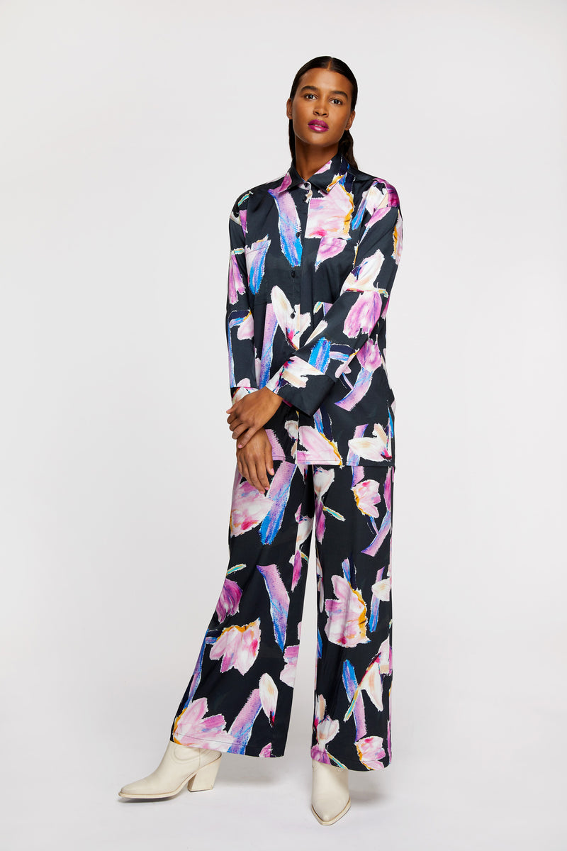 a woman wearing R/H Studio Ruby Collar Shirt and Siesta Trousers in Rain Dance print with white boots.