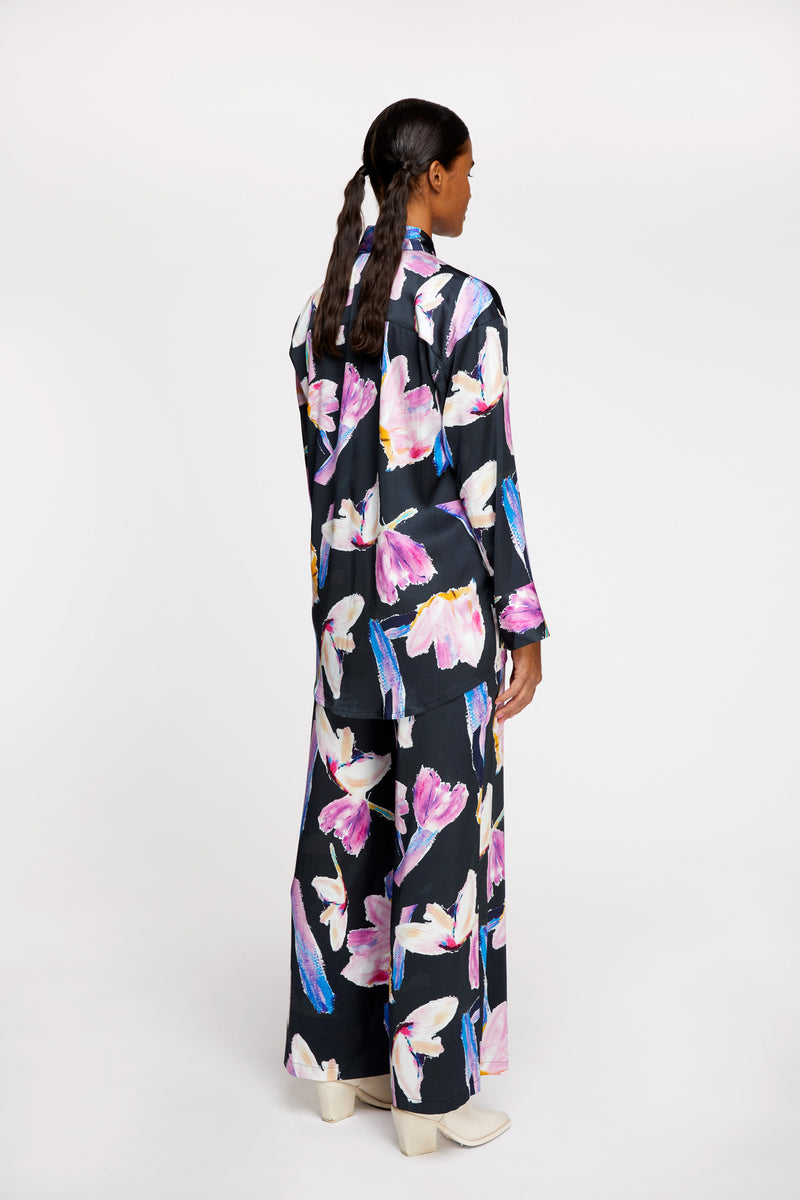 a woman wearing R/H Studio Ruby Collar Shirt and Siesta Trousers in Rain Dance print with white boots.